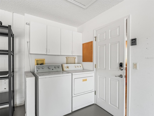 clothes washing area with a textured ceiling, independent washer and dryer, and cabinet space