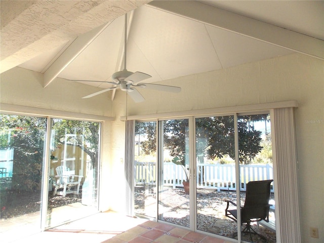 unfurnished sunroom with plenty of natural light, vaulted ceiling with beams, and ceiling fan