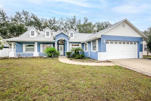 view of front of house featuring covered porch, a garage, and a front lawn