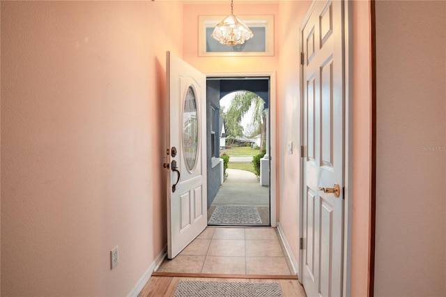 doorway to outside featuring a chandelier