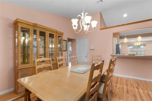 dining area featuring light hardwood / wood-style floors and a chandelier