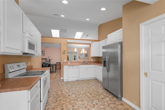 kitchen featuring sink, white cabinets, hanging light fixtures, and white appliances