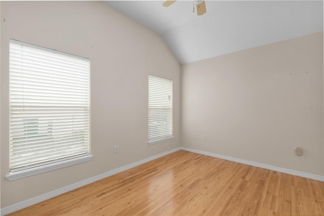 empty room with ceiling fan, lofted ceiling, and light wood-type flooring