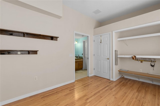 interior space featuring ensuite bath, a closet, and light hardwood / wood-style floors