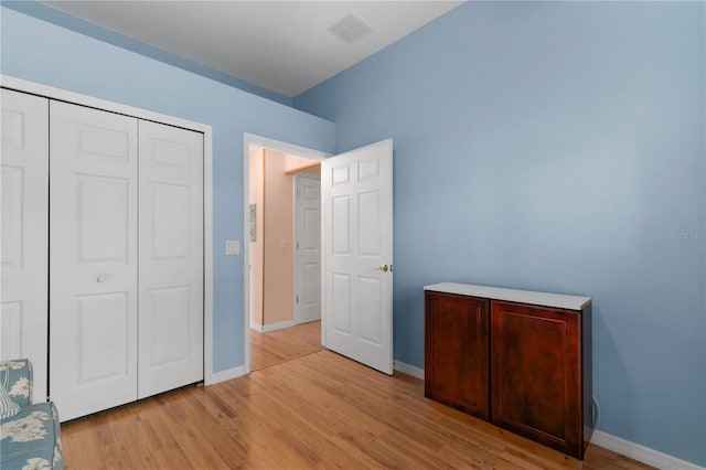 unfurnished bedroom featuring a closet and light wood-type flooring