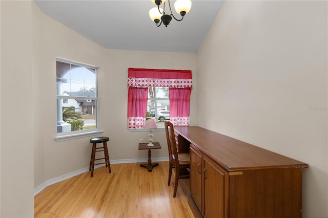 home office featuring light hardwood / wood-style floors and an inviting chandelier