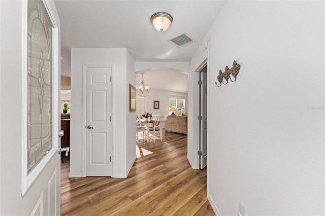 hallway featuring hardwood / wood-style floors and a notable chandelier