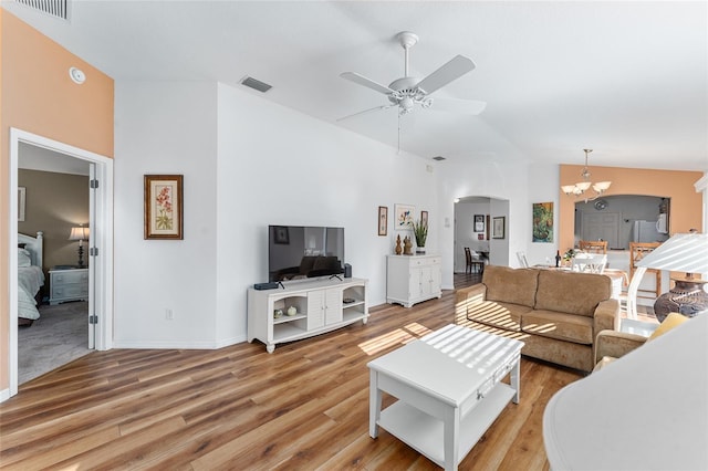 living room featuring hardwood / wood-style floors and ceiling fan with notable chandelier