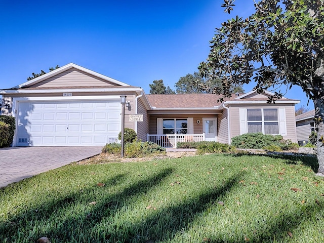 ranch-style home with a porch, a front lawn, and a garage