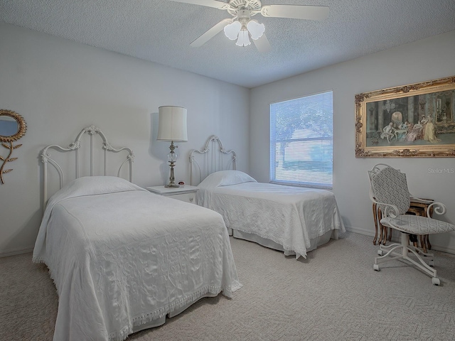 carpeted bedroom with ceiling fan and a textured ceiling