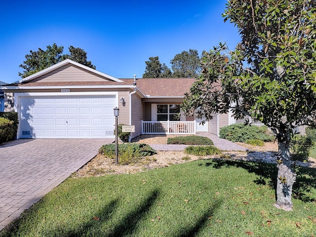 ranch-style house featuring covered porch, a front lawn, and a garage