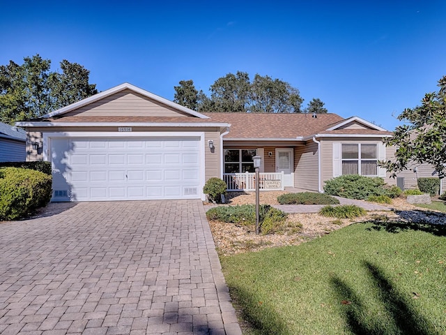 ranch-style home featuring a porch, a front lawn, and a garage