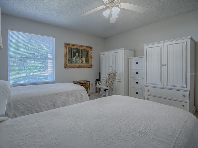 bedroom with ceiling fan and a textured ceiling