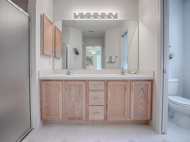 bathroom with toilet, vanity, and a shower with shower door