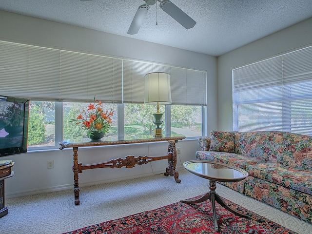 carpeted living room with a textured ceiling, ceiling fan, and a wealth of natural light