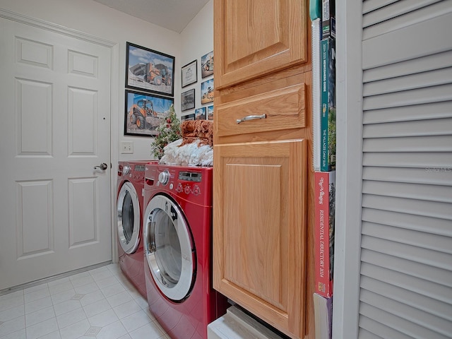 washroom featuring washer and dryer, cabinets, and light tile patterned floors