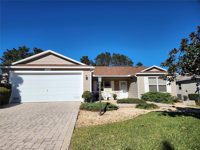 ranch-style home with a garage, covered porch, and a front lawn