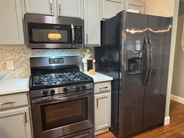 kitchen with tasteful backsplash, light hardwood / wood-style floors, stainless steel appliances, and white cabinetry