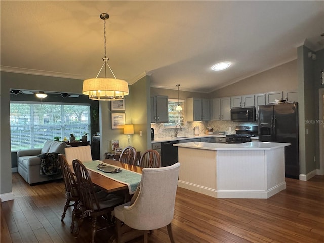 dining area featuring lofted ceiling, dark hardwood / wood-style flooring, sink, and crown molding