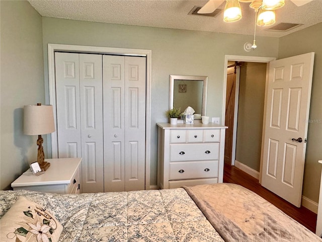 bedroom featuring a textured ceiling, ceiling fan, a closet, and dark hardwood / wood-style floors