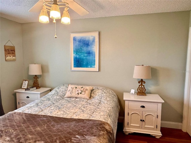 bedroom featuring a textured ceiling, ceiling fan, and dark hardwood / wood-style floors