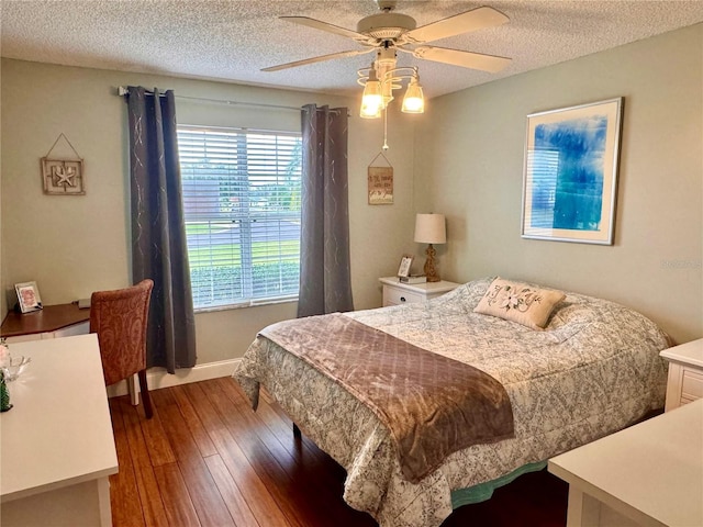 bedroom with a textured ceiling, ceiling fan, and hardwood / wood-style floors