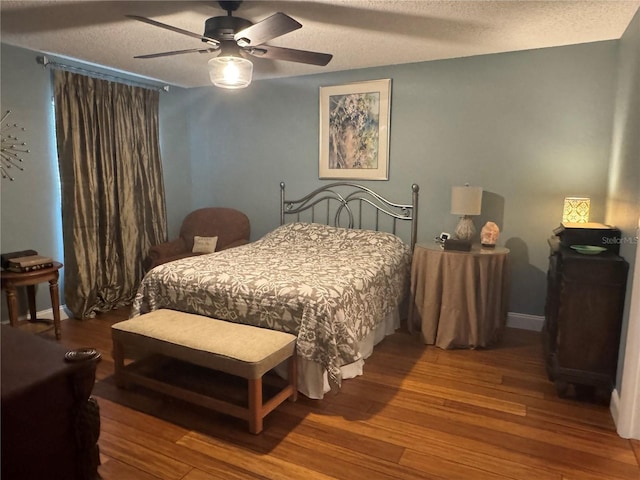 bedroom with ceiling fan, a textured ceiling, and wood-type flooring