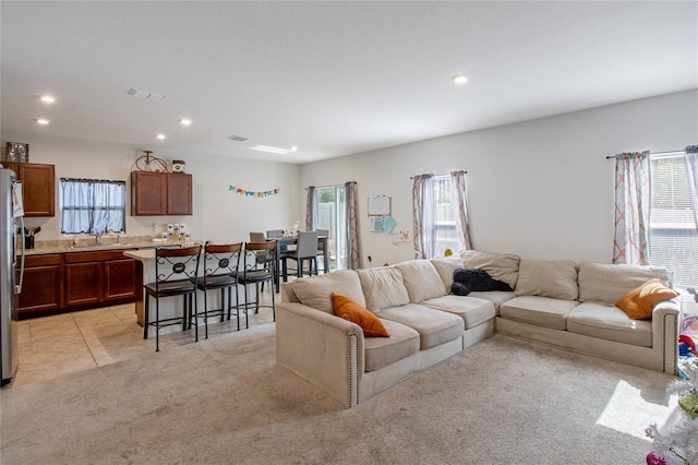 carpeted living room featuring a wealth of natural light and sink