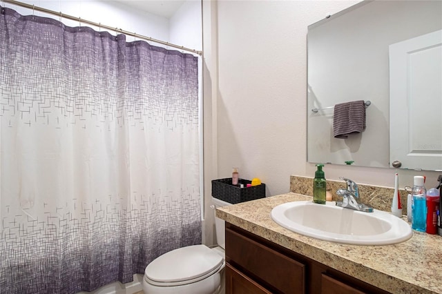 bathroom featuring vanity, toilet, and walk in shower