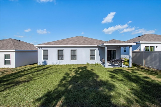 rear view of house featuring a yard and a patio