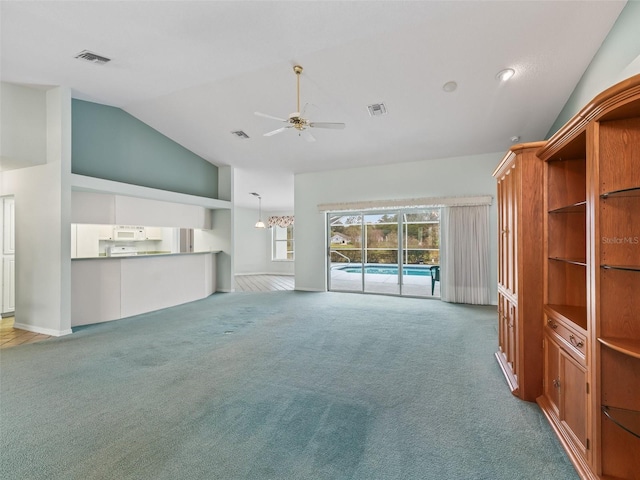 unfurnished living room featuring lofted ceiling, light carpet, and ceiling fan with notable chandelier