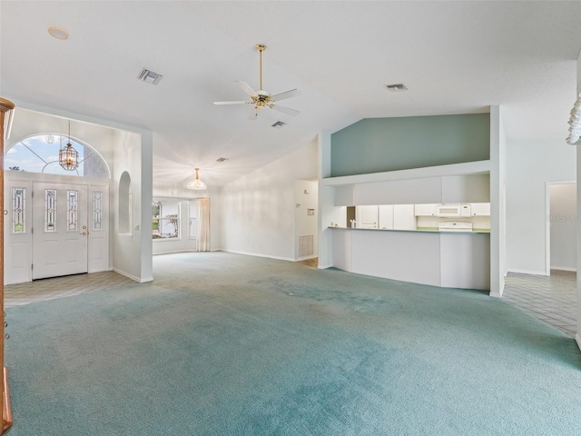 unfurnished living room with carpet flooring, high vaulted ceiling, and ceiling fan with notable chandelier