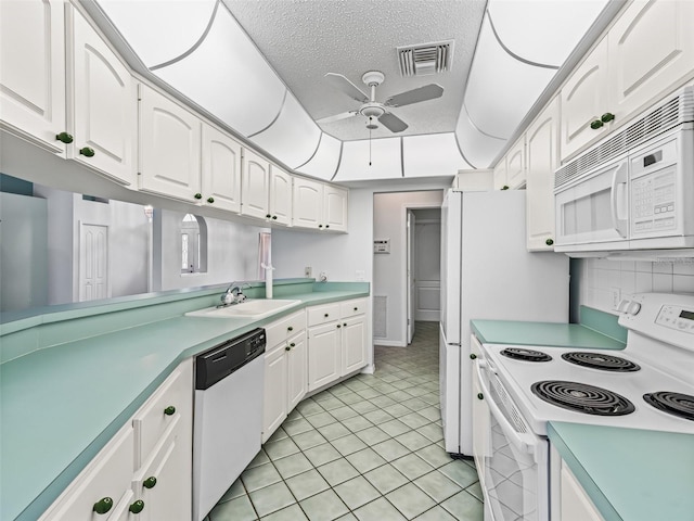 kitchen with white appliances, white cabinets, sink, ceiling fan, and a textured ceiling