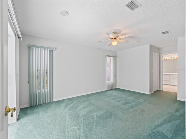 carpeted empty room featuring ceiling fan and a textured ceiling