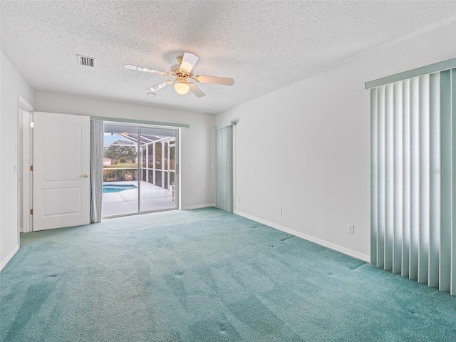 spare room featuring a textured ceiling, carpet floors, and ceiling fan