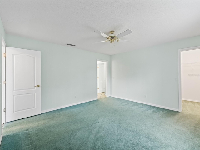 unfurnished room featuring carpet flooring, a textured ceiling, and ceiling fan