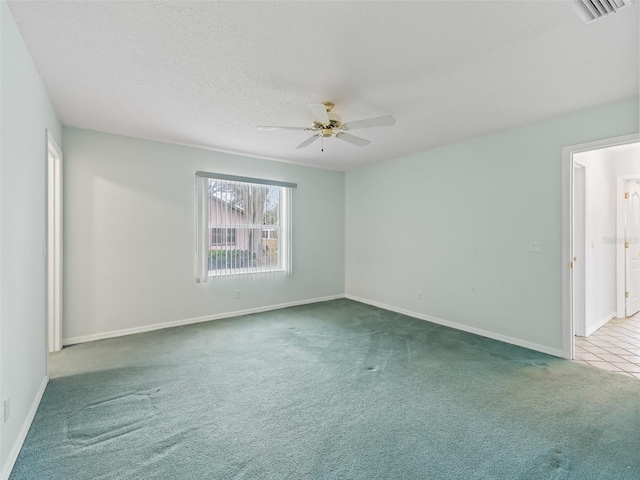 carpeted empty room featuring ceiling fan and a textured ceiling