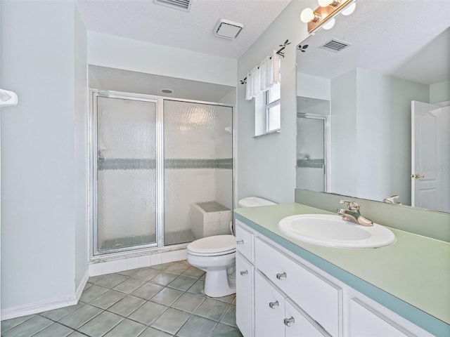 bathroom featuring tile patterned floors, a textured ceiling, toilet, a shower with door, and vanity