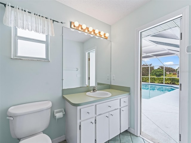 bathroom with tile patterned floors, a healthy amount of sunlight, a textured ceiling, and toilet