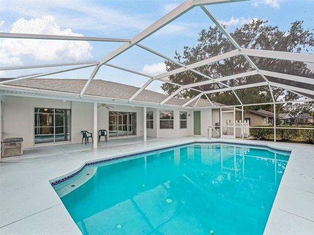 view of swimming pool featuring ceiling fan, a lanai, and a patio