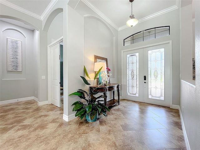 entryway featuring french doors, a towering ceiling, and ornamental molding