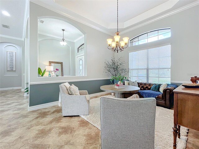 living room with a notable chandelier, a raised ceiling, and crown molding