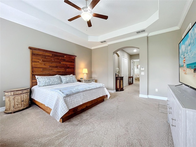 carpeted bedroom with ceiling fan, ornamental molding, and a tray ceiling