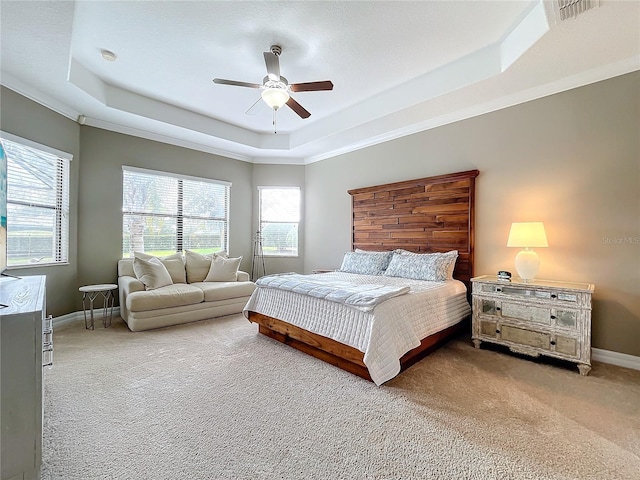 bedroom featuring ceiling fan, a raised ceiling, carpet floors, and ornamental molding