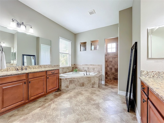 bathroom with vanity and independent shower and bath