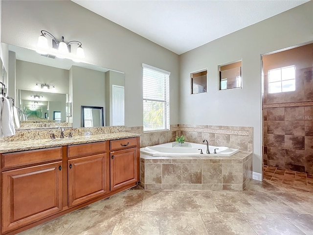 bathroom with vanity and independent shower and bath