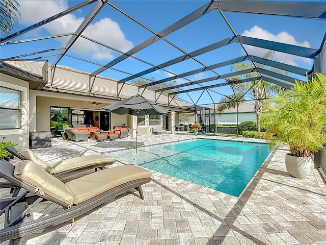 view of swimming pool featuring a lanai, ceiling fan, a patio, and an outdoor hangout area