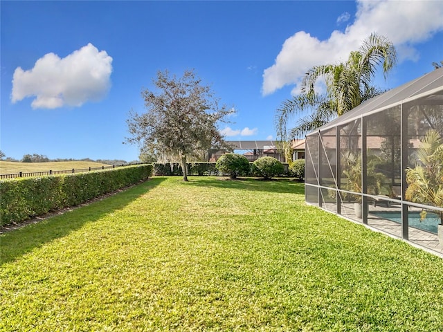 view of yard featuring a fenced in pool and glass enclosure