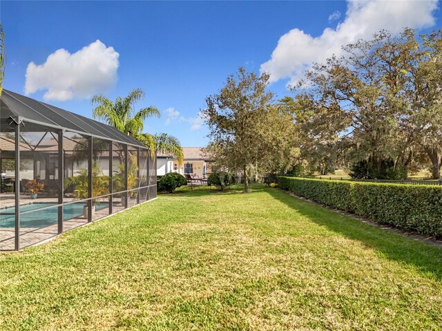 view of yard with a fenced in pool and a lanai