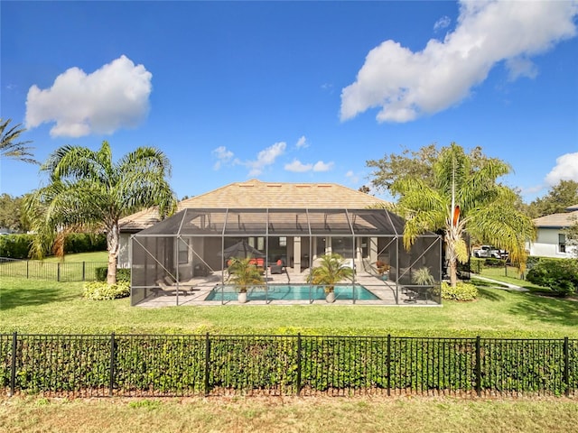 exterior space featuring a lawn, glass enclosure, and a fenced in pool